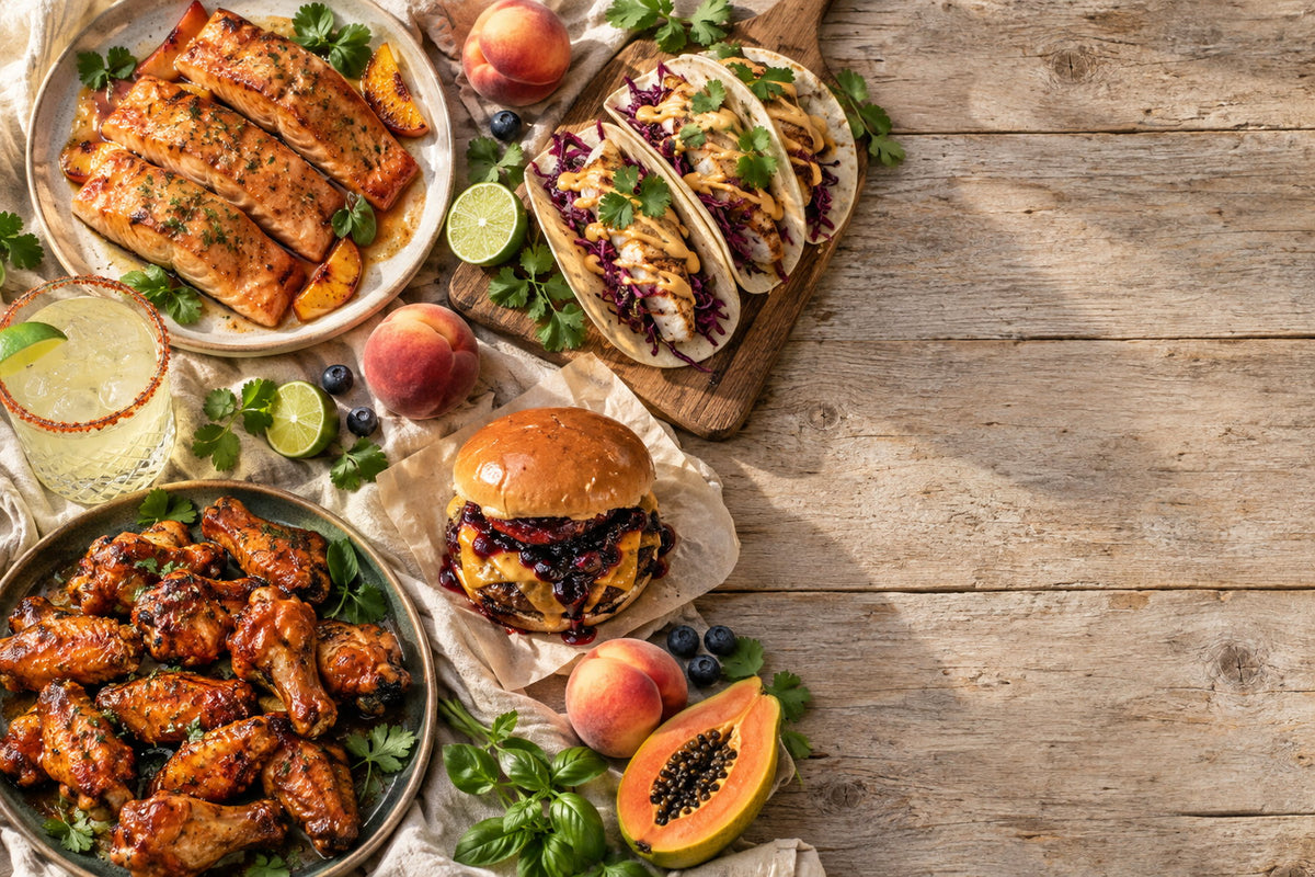 An overhead spread of Long Island Pepper Company recipes: glazed salmon, fish tacos, a blueberry reaper burger, papaya reaper wings and a mango margarita
